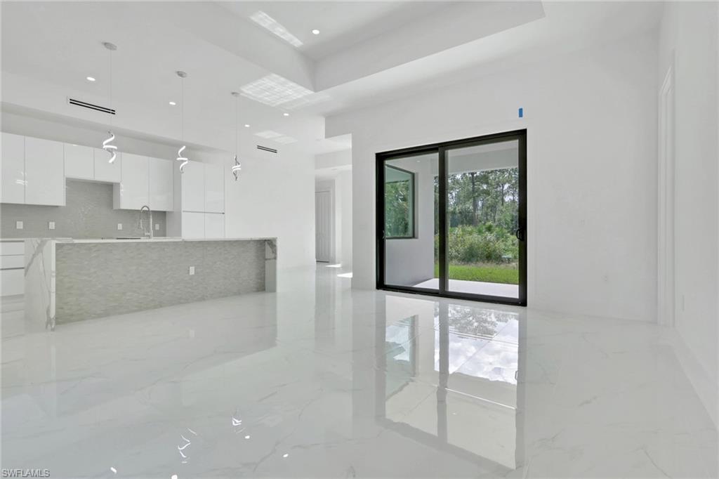 3780 6th Avenue Southeast Naples, FL 34117 - Photo 6 of 33 a open kitchen with white cabinets and a large window