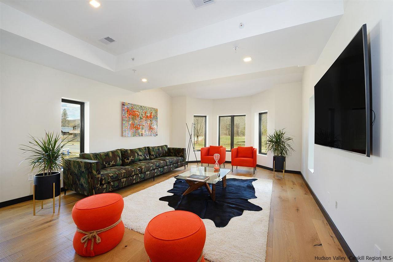 7717 Main Street Hunter, NY 12442 - Photo 11 of 32 a living room with furniture a flat screen tv and a large window