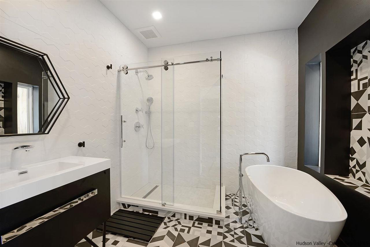 7717 Main Street Hunter, NY 12442 - Photo 25 of 32 a bathroom with a sink a toilet a mirror and shower