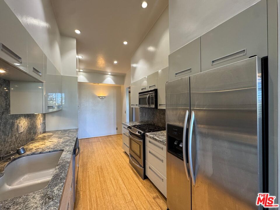 5100 Vía Dolce, Unit 305 Marina del Rey, CA 90292 - Photo 27 of 54 a kitchen with stainless steel appliances granite countertop a refrigerator and a sink