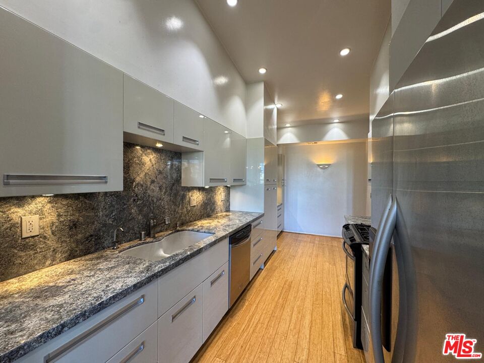 5100 Vía Dolce, Unit 305 Marina del Rey, CA 90292 - Photo 28 of 54 a bathroom with a granite countertop sink a mirror and a shower