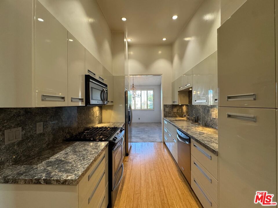 5100 Vía Dolce, Unit 305 Marina del Rey, CA 90292 - Photo 30 of 54 a large kitchen with stainless steel appliances granite countertop a stove and a sink