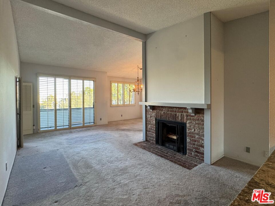 5100 Vía Dolce, Unit 305 Marina del Rey, CA 90292 - Photo 32 of 54 a view of an empty room with a fireplace and a window