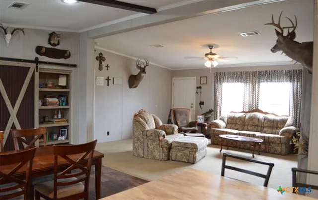a living room with furniture a rug and a bookshelf
