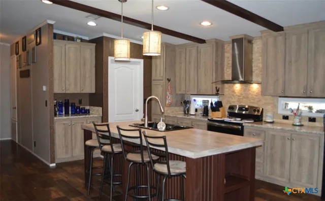 a kitchen with kitchen island granite countertop a table chairs sink and cabinets
