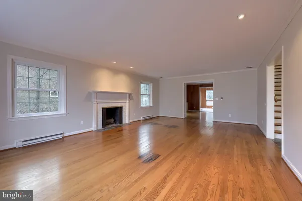 a view of empty room with wooden floor and fireplace