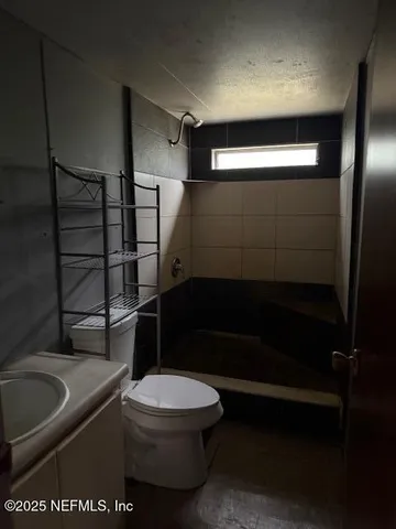a bathroom with a toilet and a shower