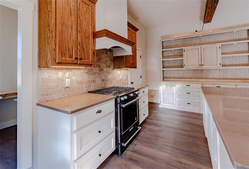 1433 County Road 1180 Decatur, TX 76234 - Photo 6 of 36 a kitchen with granite countertop wooden cabinets and white appliances