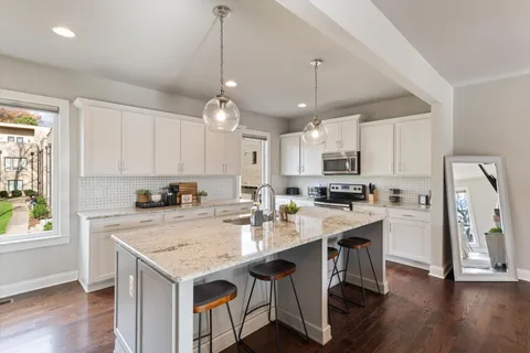 a kitchen with a center island wooden floor cabinets and a window