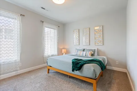 a bedroom with a bed and windows