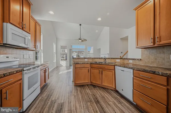 a kitchen with stainless steel appliances granite countertop wooden cabinets stove top oven and sink