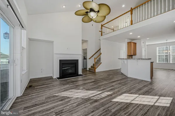 a view of a livingroom with wooden floor and a ceiling fan