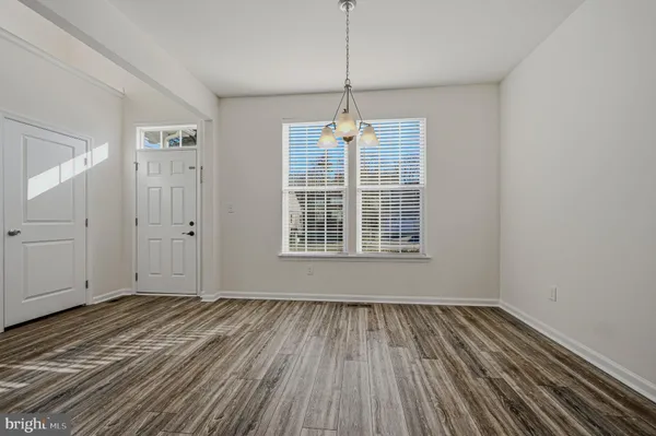 a view of wooden floor in an empty room with a window