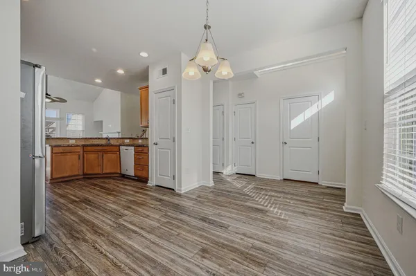 a view of a kitchen with a sink and dishwasher a refrigerator with wooden floor