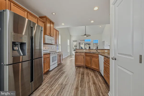a kitchen with a refrigerator a sink and dishwasher a refrigerator with wooden floor