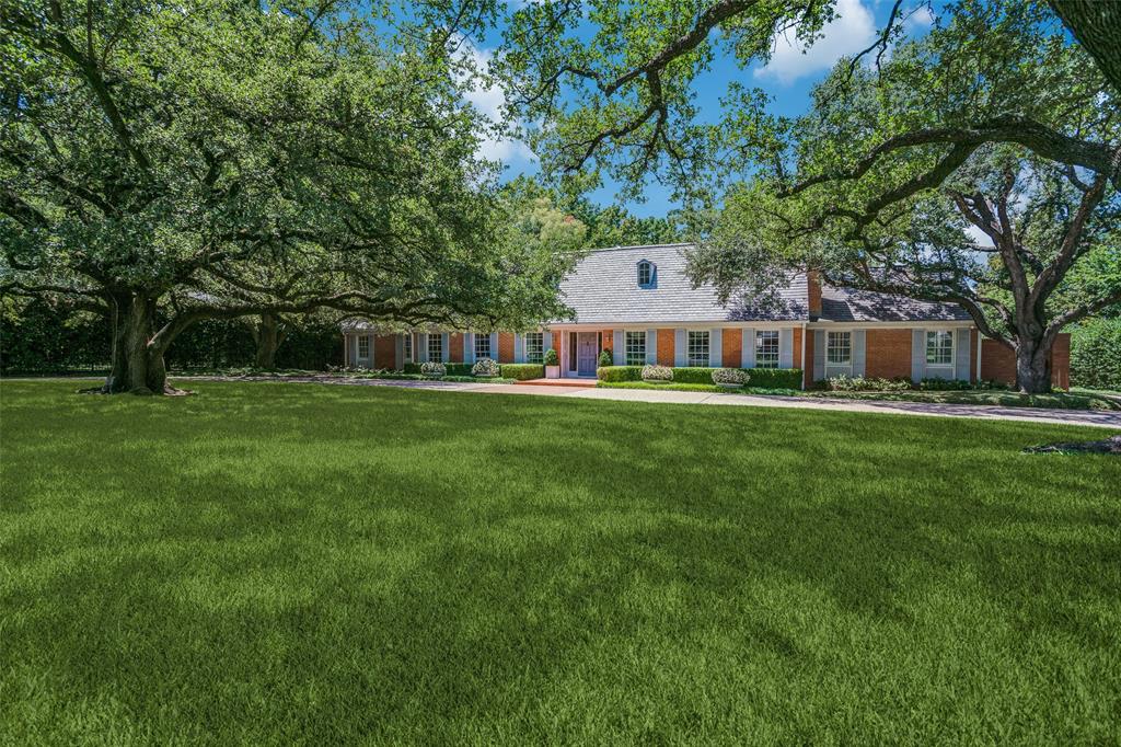 a front view of a house with a garden and trees