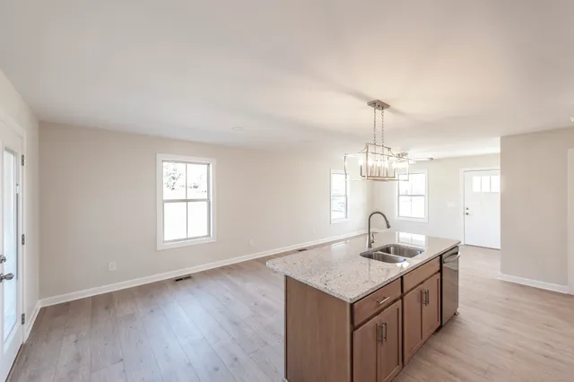 a kitchen with a sink cabinets and wooden floor