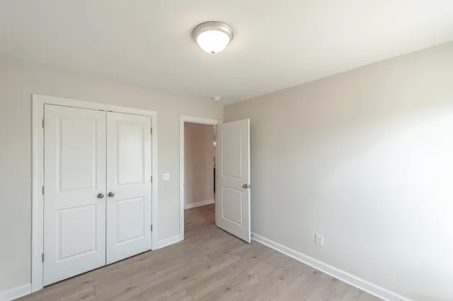 an empty room with wooden floor and closet