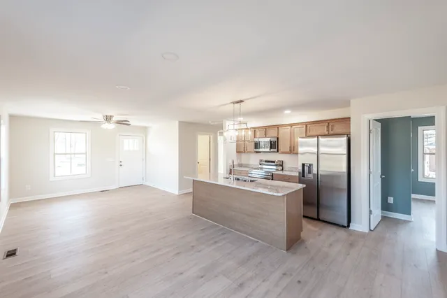 a view of a kitchen with a sink a refrigerator and window