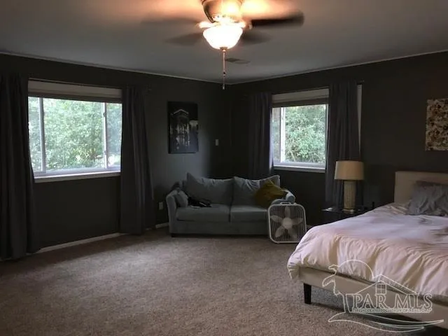 a spacious bedroom with a bed and a chandelier