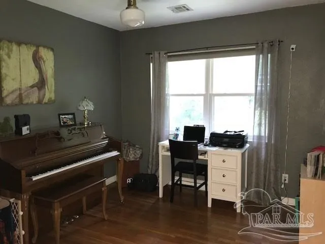 a view of a workspace with furniture and a window