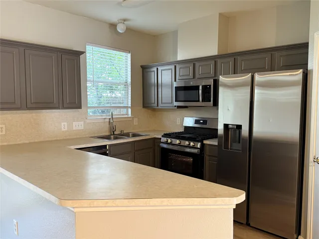 a kitchen with a refrigerator stove and sink
