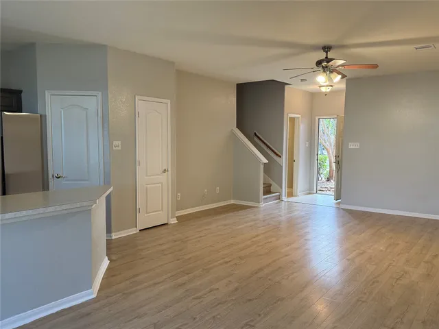a view of an empty room with window and wooden floor