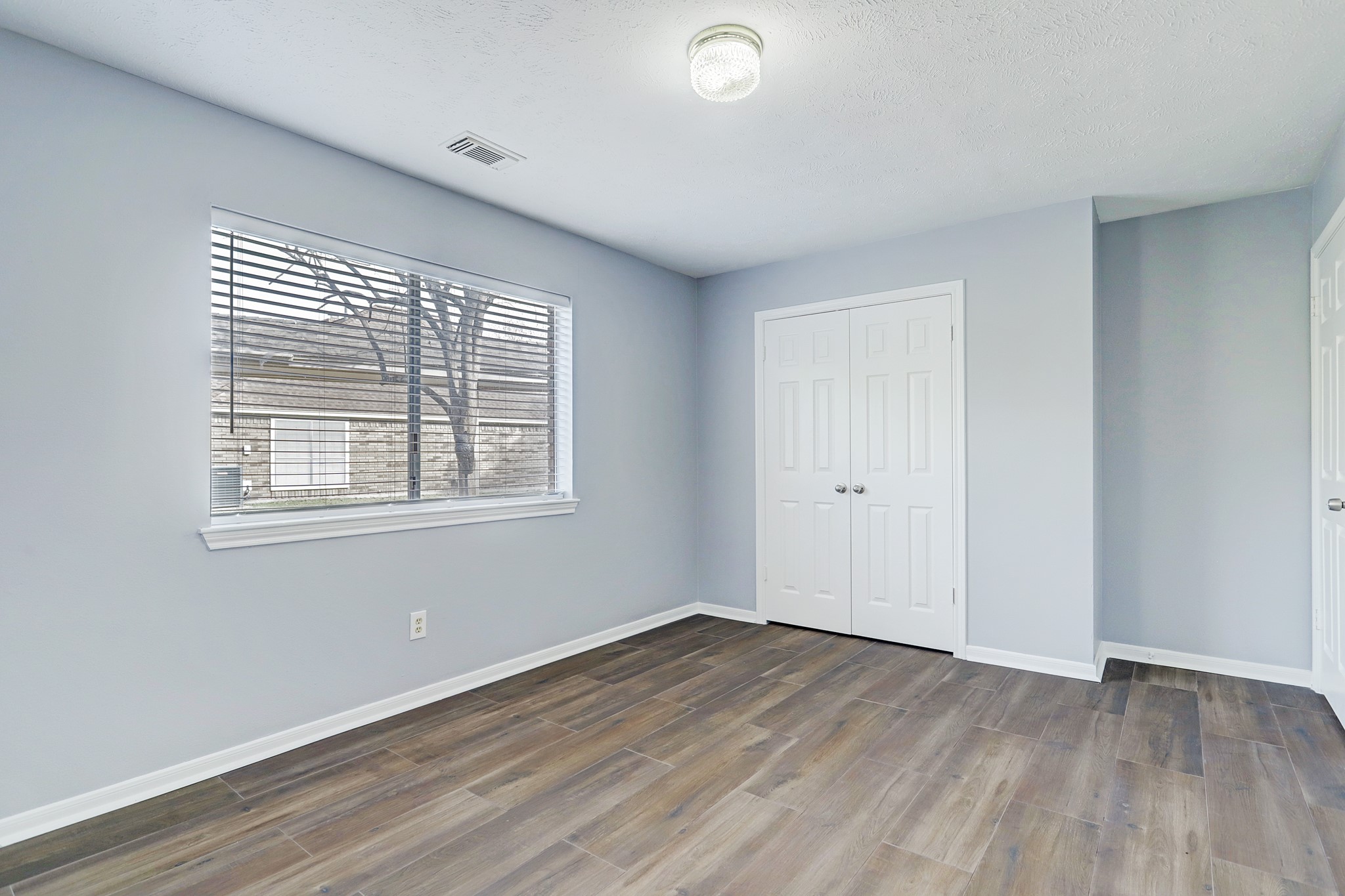 7403 Manor Bridge Court Houston, TX 77095 - Photo 9 of 11 an empty room with wooden floor and windows