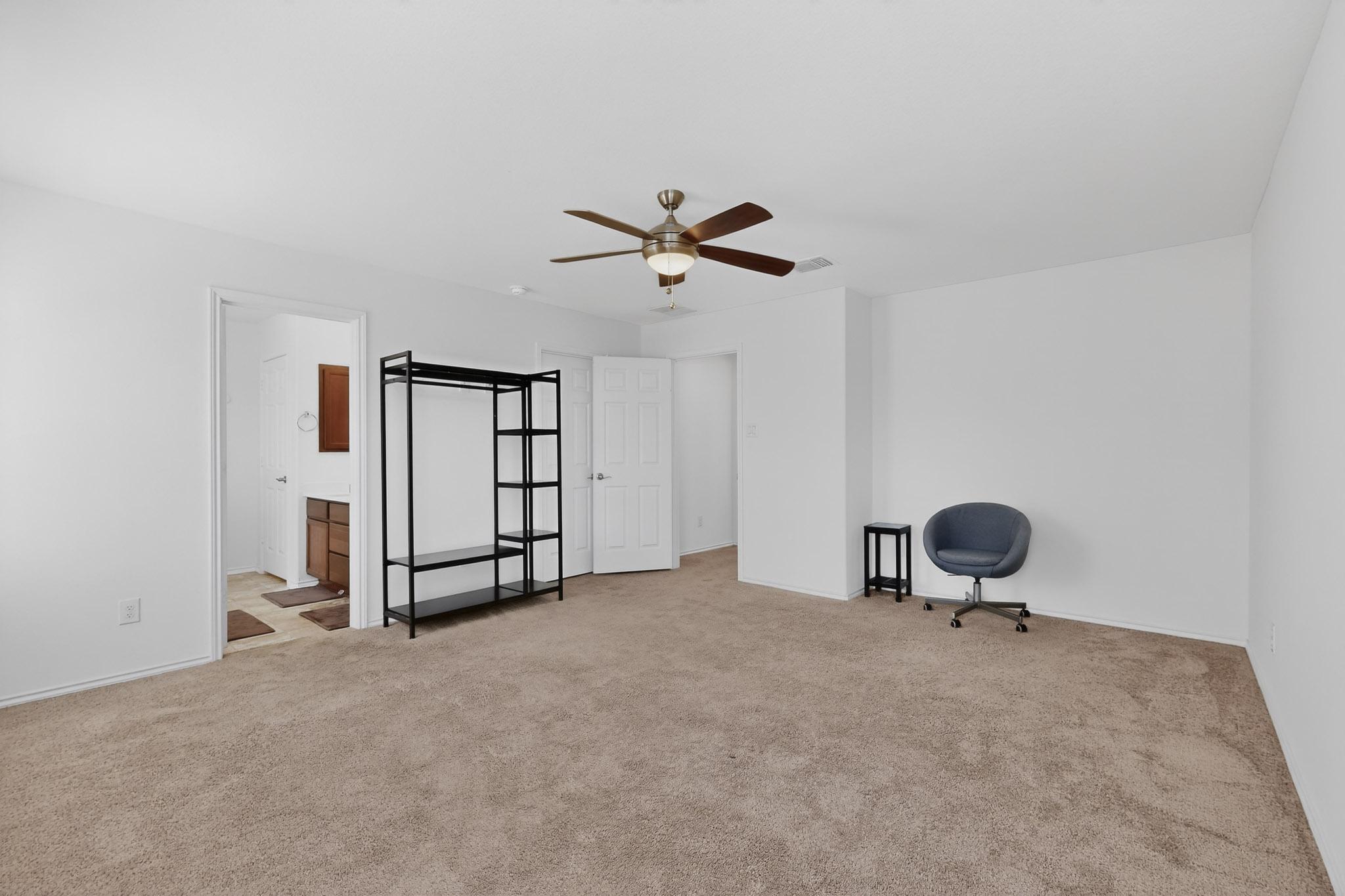 712 Madalin Rue Court Leander, TX 78641 - Photo 11 of 28 Unfurnished bedroom featuring ceiling fan, light colored carpet, and connected bathroom
