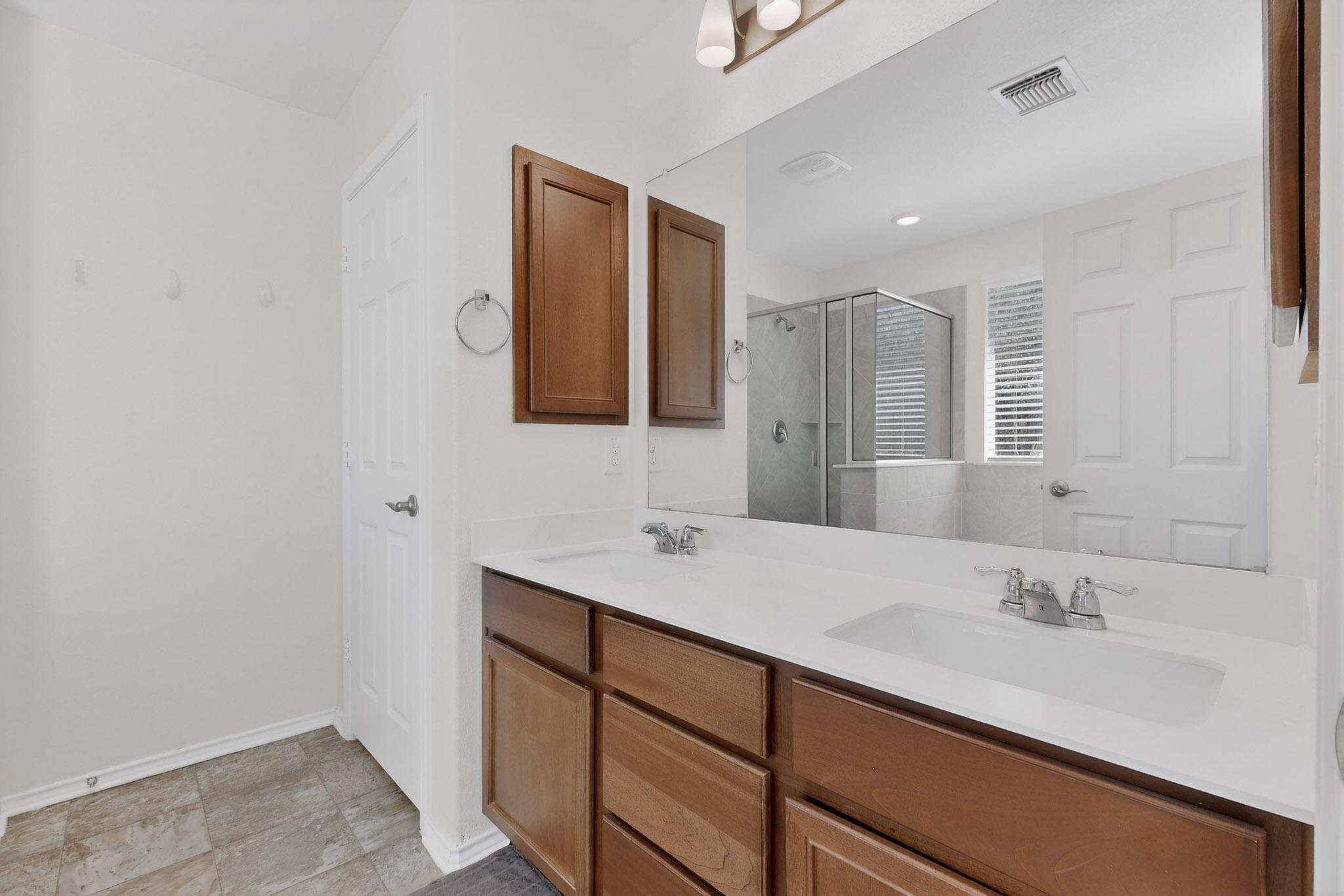 712 Madalin Rue Court Leander, TX 78641 - Photo 12 of 28 Full bath with double vanity and a stall shower
