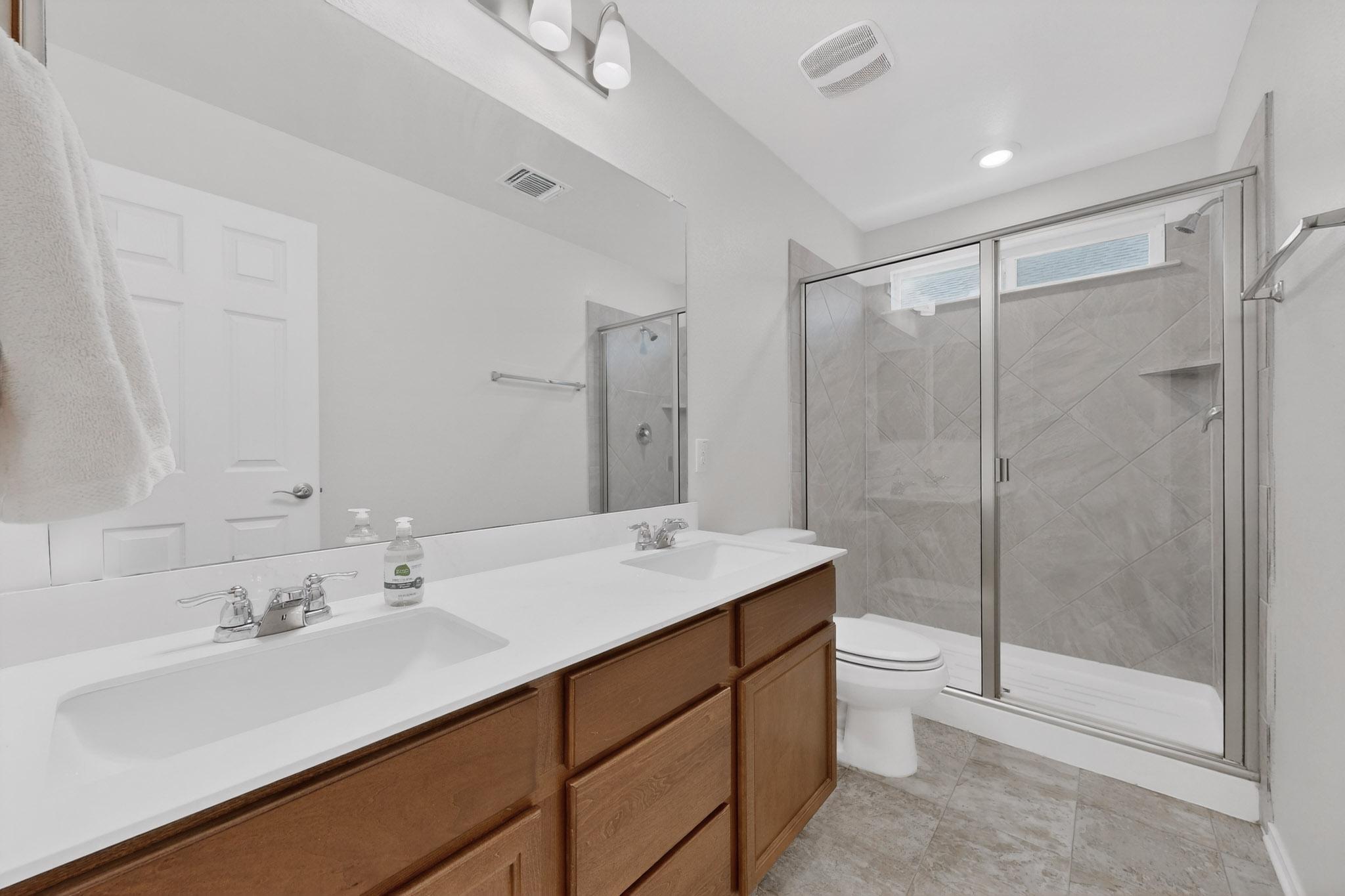 712 Madalin Rue Court Leander, TX 78641 - Photo 15 of 28 Full bathroom with double vanity and a shower stall