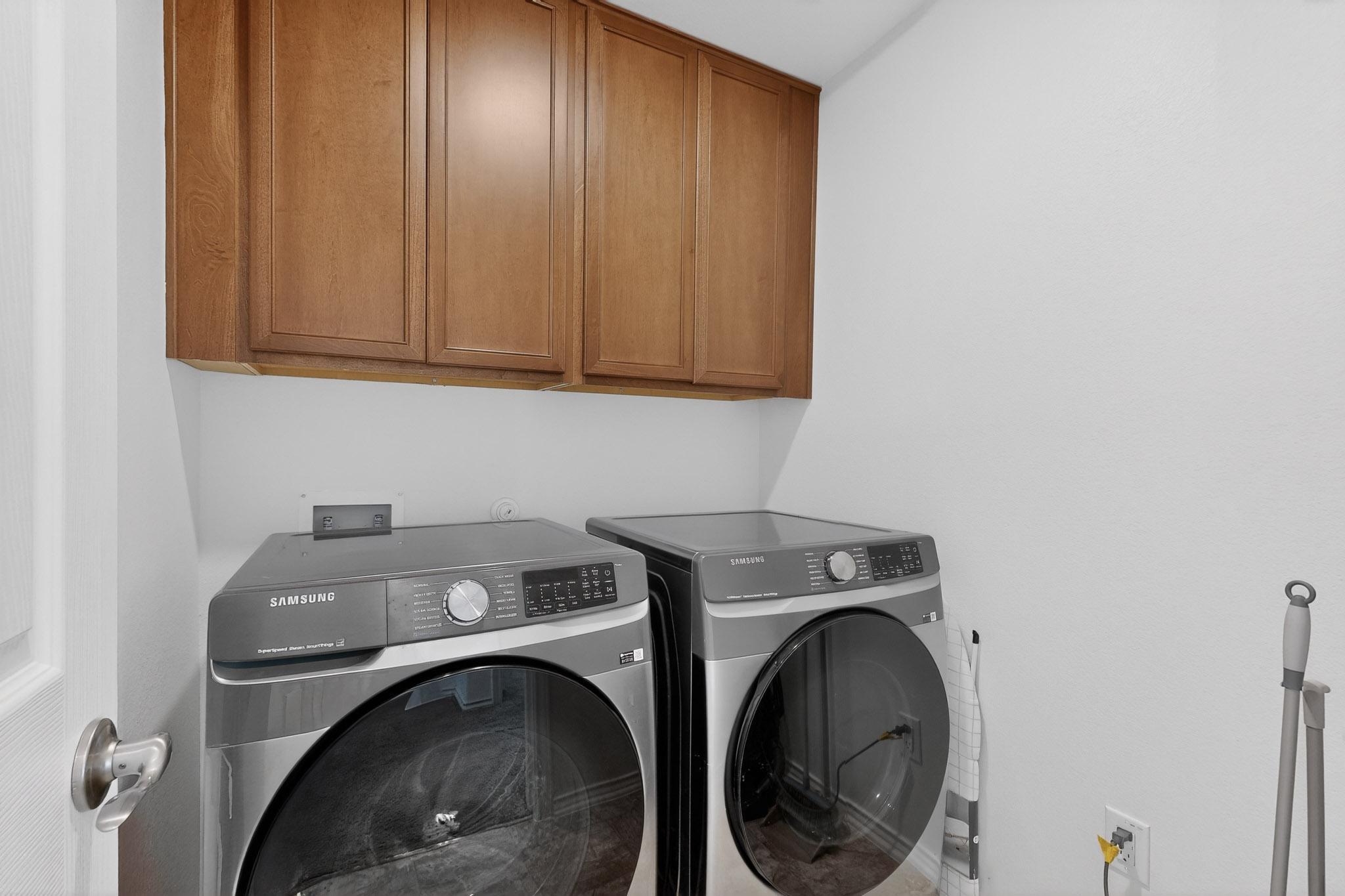 712 Madalin Rue Court Leander, TX 78641 - Photo 21 of 28 Laundry area with cabinet space and independent washer and dryer