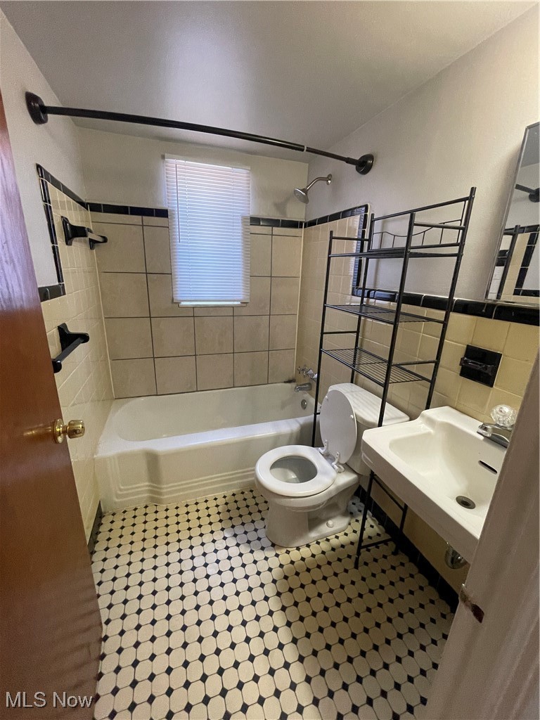 19860 Lorain Road, Unit 1 Cleveland, OH 44126 - Photo 3 of 8 Full bath with toilet, shower / bathtub combination, tile patterned floors, tile walls, and a sink