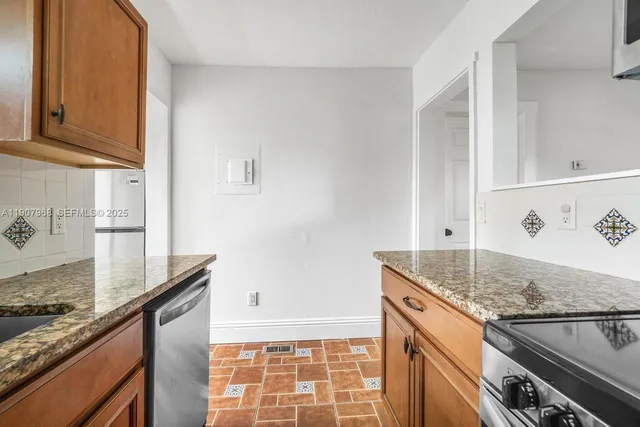 a kitchen with granite countertop a sink and a stove