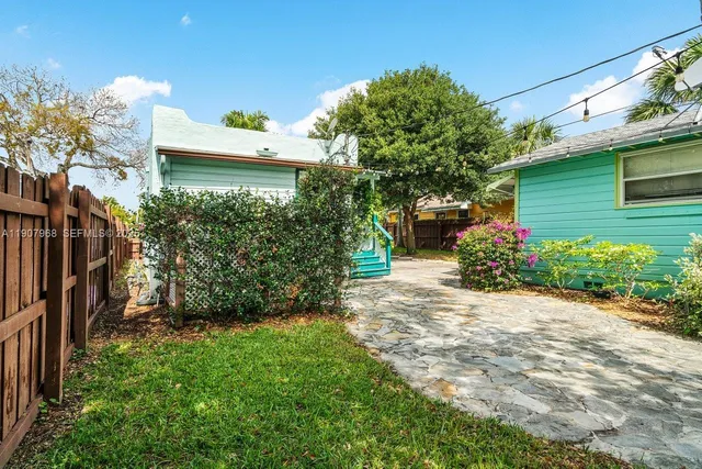 a view of a house with a yard and potted plants