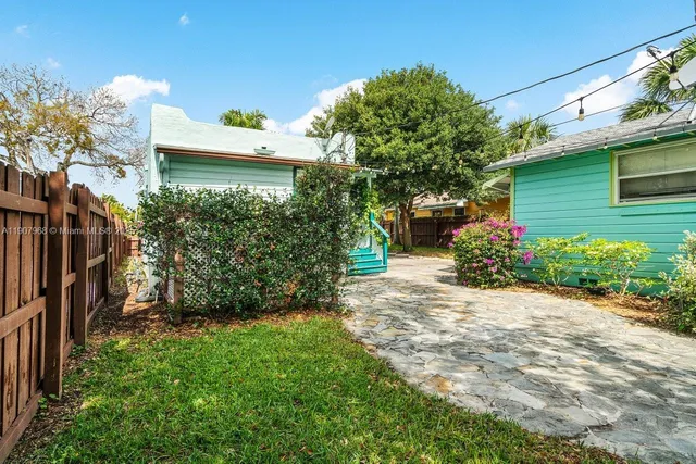 a view of a house with a yard and potted plants