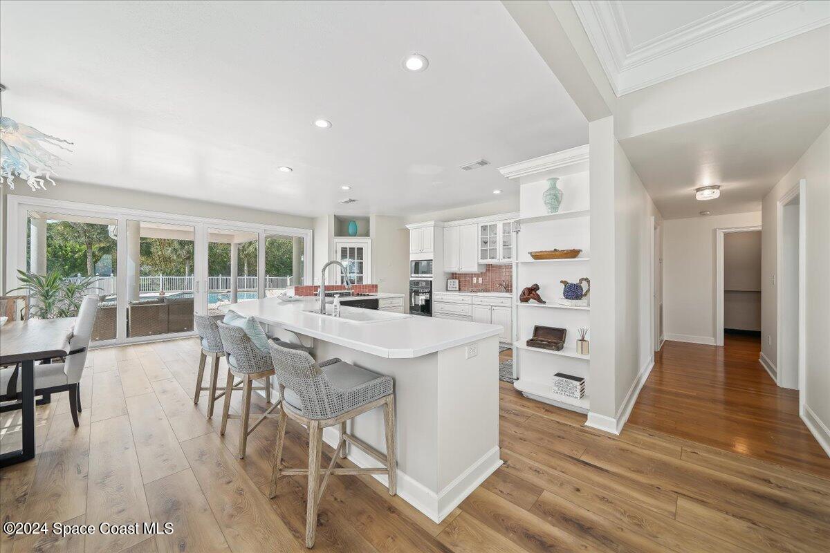 2420 Rocky Point Road Malabar, FL 32950 - Photo 33 of 97 a kitchen with stainless steel appliances kitchen island granite countertop a table chairs and a view of living room