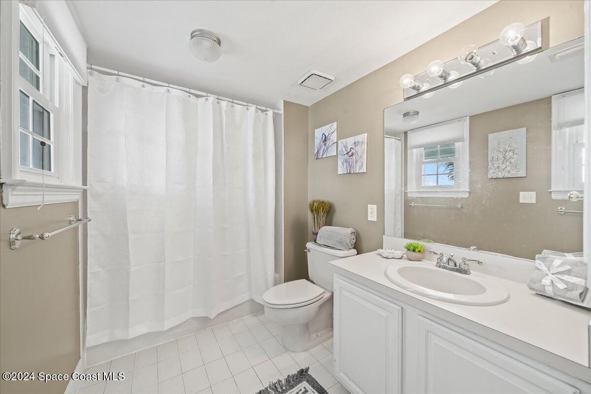 2420 Rocky Point Road Malabar, FL 32950 - Photo 44 of 97 a bathroom with a sink a toilet and shower curtain