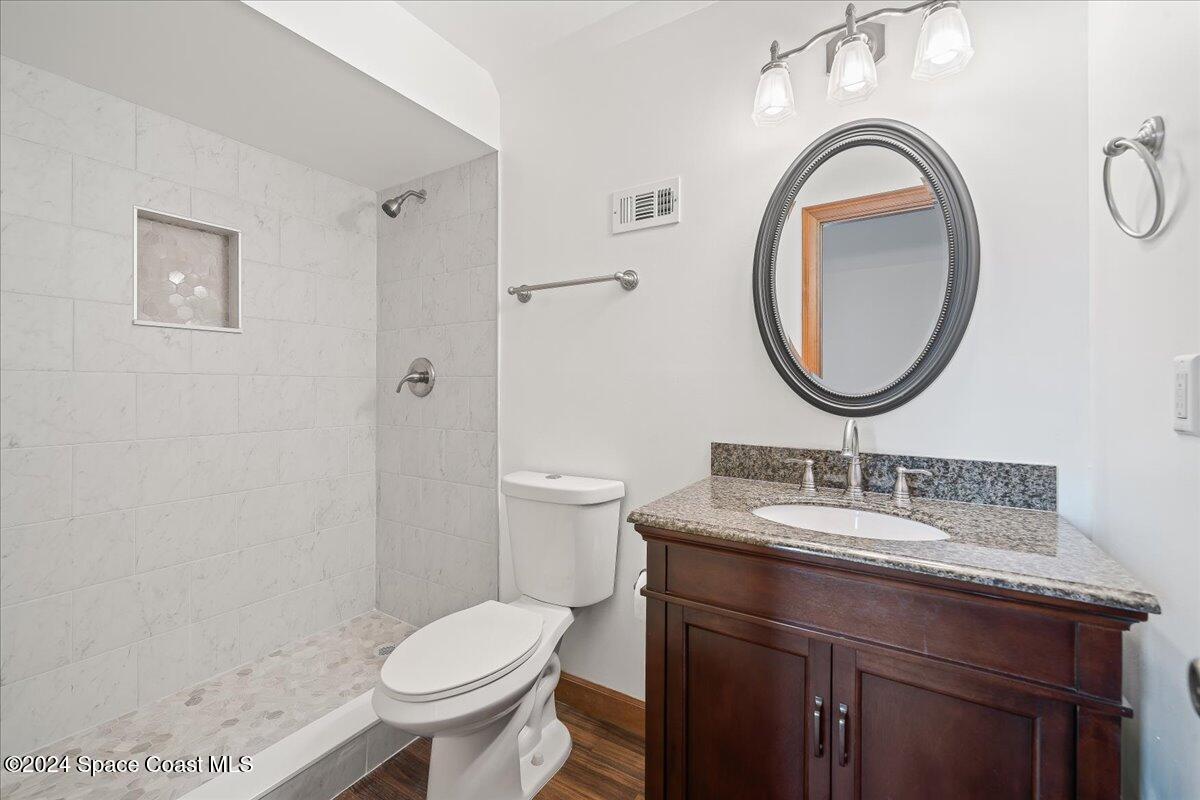 2420 Rocky Point Road Malabar, FL 32950 - Photo 65 of 97 a bathroom with a granite countertop toilet sink and mirror