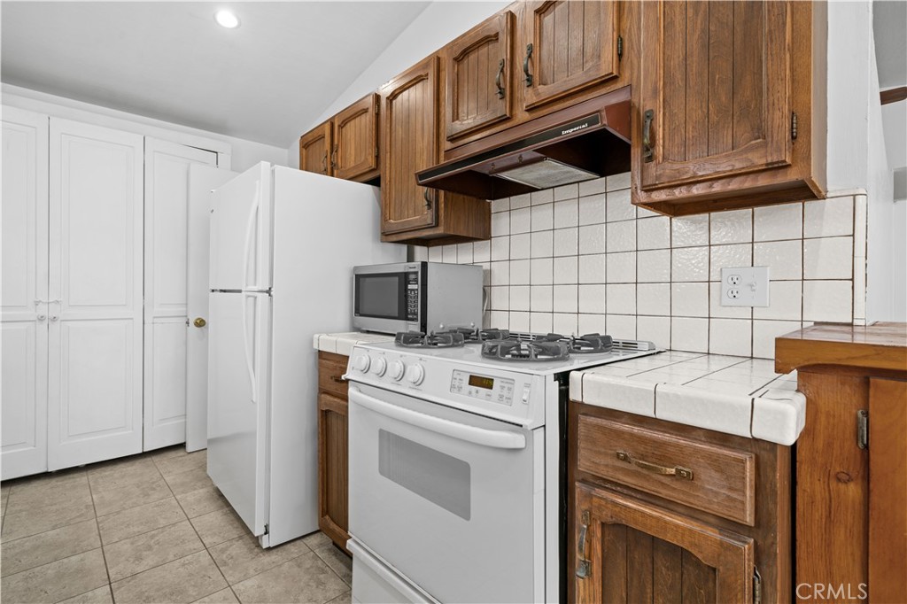 2115 Sterling Avenue Costa Mesa, CA 92627 - Photo 29 of 53 a kitchen with stainless steel appliances granite countertop a stove a refrigerator and a cabinets
