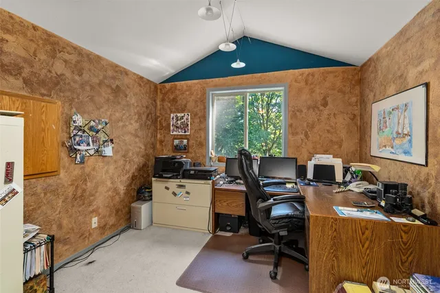 a view of a workspace with furniture and a window