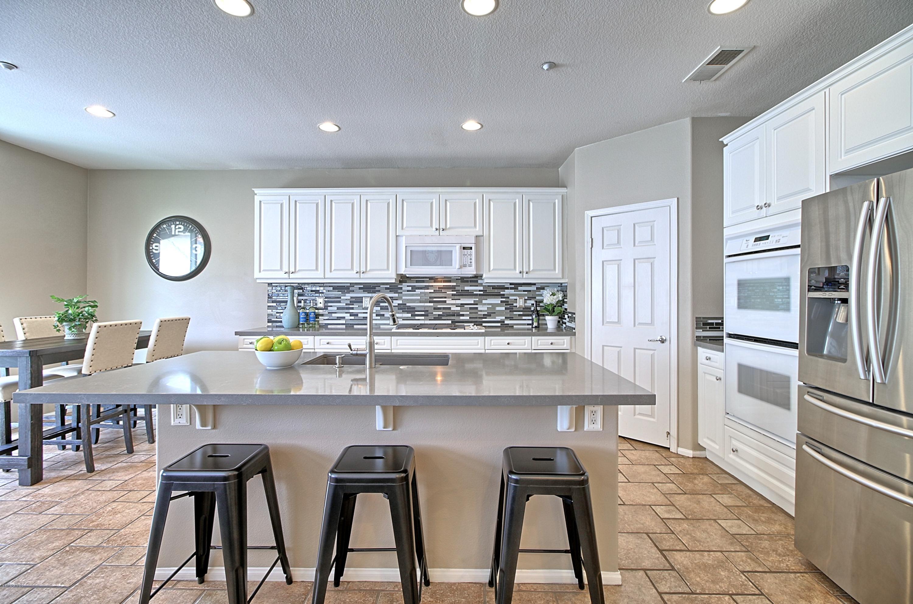 3305 Dunkirk Drive Oxnard, CA 93035 - Photo 7 of 20 a kitchen with stainless steel appliances a table chairs and a refrigerator