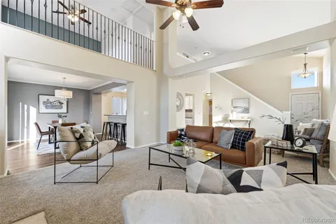 a living room with furniture and a ceiling fan