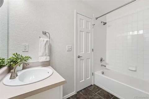 a bathroom with a sink a bathtub and a mirror