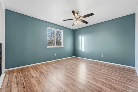 a view of a big room with wooden floor and windows