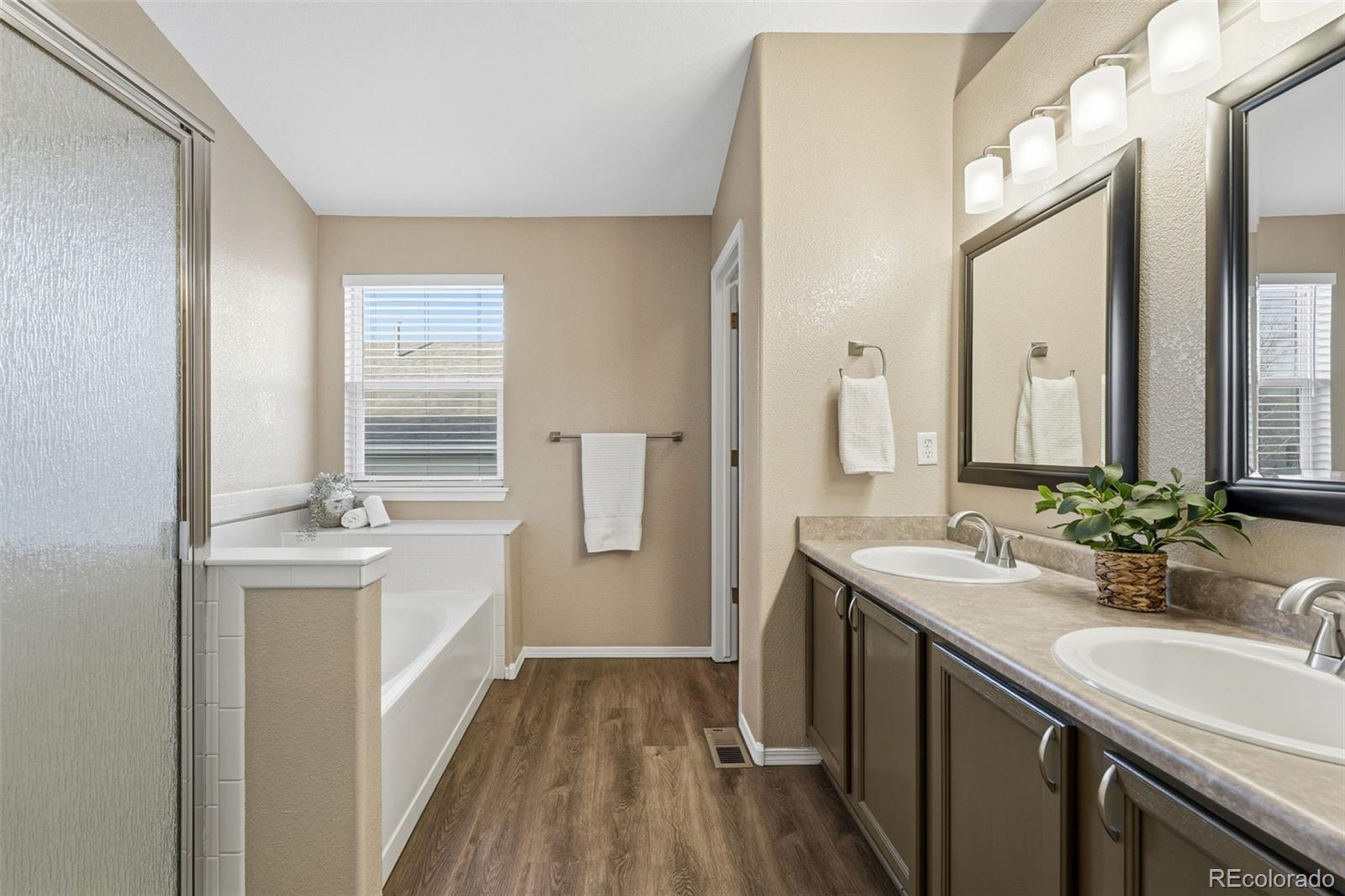 6471 St Vrain Ranch Boulevard Firestone, CO 80504 - Photo 30 of 45 a bathroom with a sink a mirror and a shower