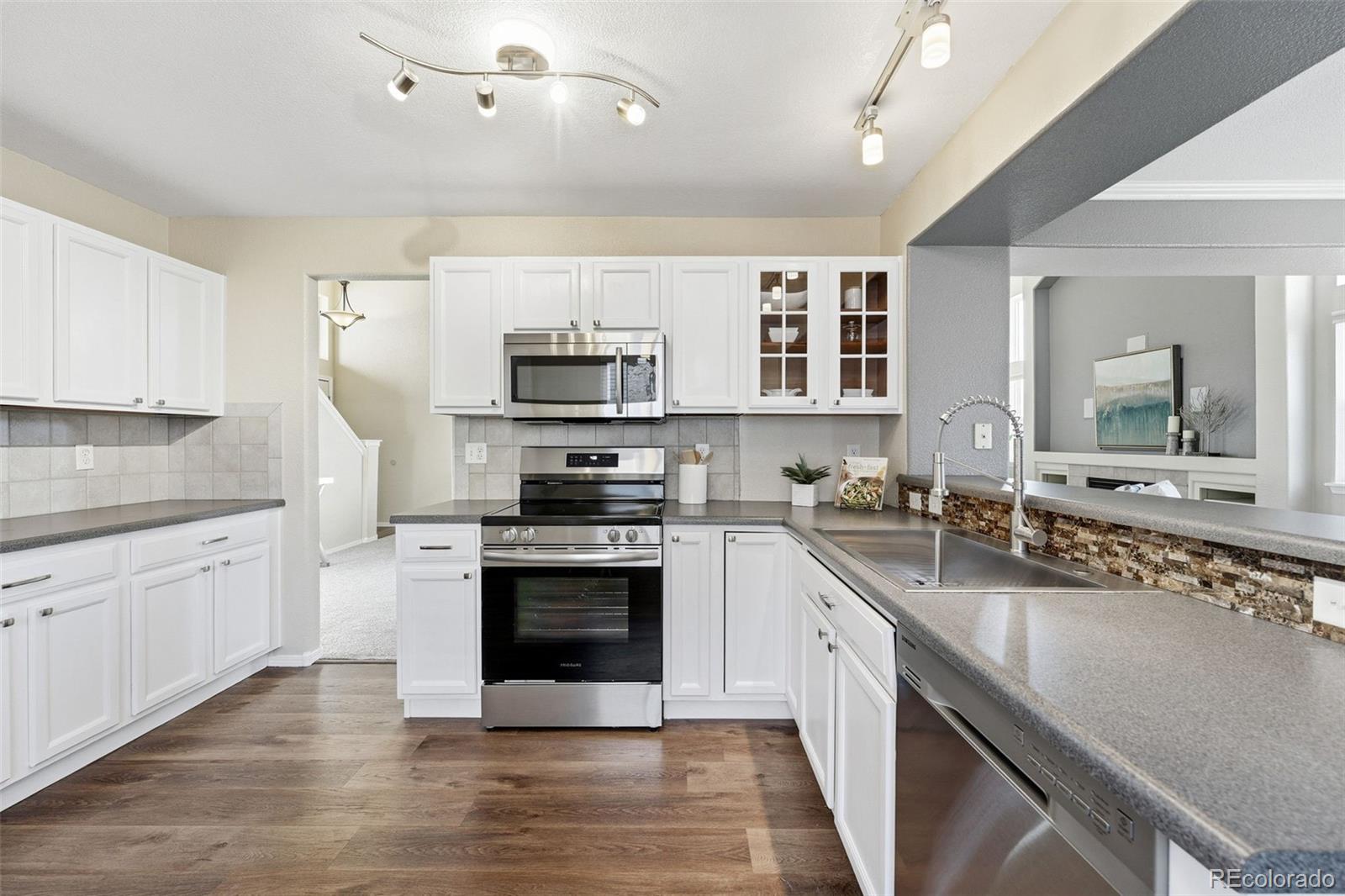 6471 St Vrain Ranch Boulevard Firestone, CO 80504 - Photo 3 of 45 a large kitchen with stainless steel appliances granite countertop a stove and a sink