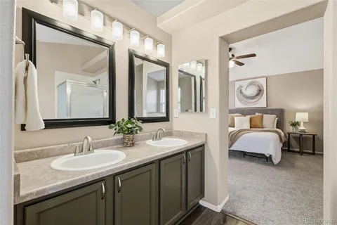 a en suite bathroom with a granite countertop sink and a mirror