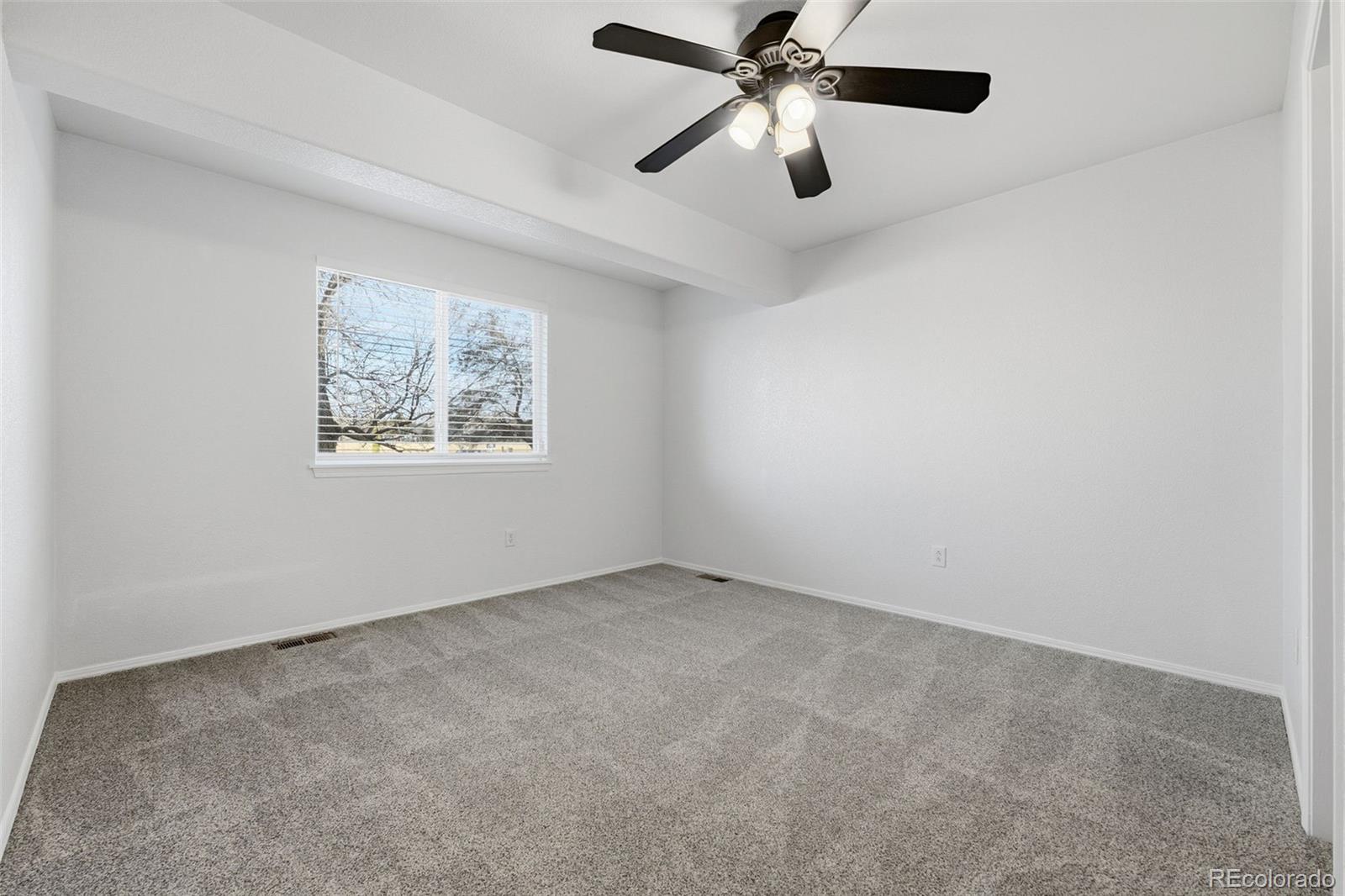 6471 St Vrain Ranch Boulevard Firestone, CO 80504 - Photo 33 of 45 an empty room with a window and a fan