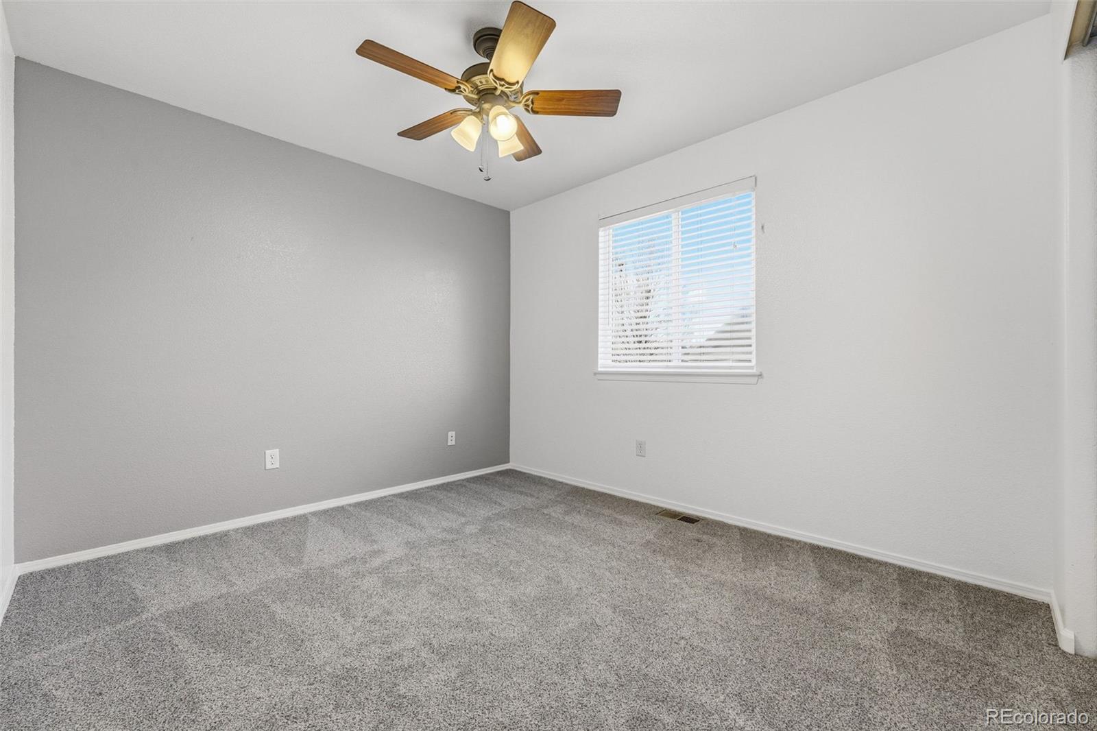 6471 St Vrain Ranch Boulevard Firestone, CO 80504 - Photo 36 of 45 an empty room with a window and a fan